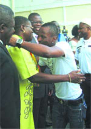 Akua Sena Dansua gives the Champ a welcome hug on his arrivial. Looking on is Mr. Kwetey