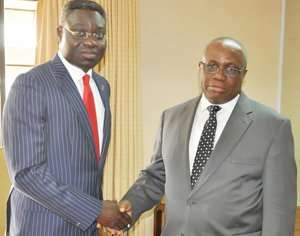 Dr Wampah in a handshake with Philip Oduoza