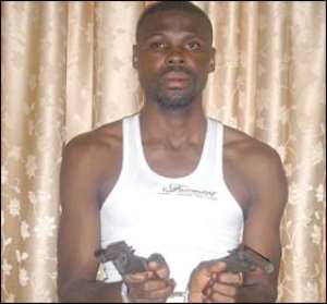 George Kofi Adu aka 'My People' holding the two pistols