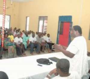 Dr Abu Sakara standing, in white smocks, addressing constituency and regional executives of the party in Brong Ahafo Region at the VAG Hall in Sunyani.
