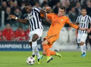 Kwadwo Asamoah of Juventus L and Gareth Bale of Real Madrid compete for the ball during the UEFA Champions League Group B match