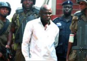 Kombian being escorted out of the court by security personnel.