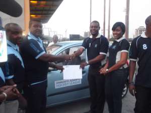 Awuku (L) in a handshake with Amonoo after handing over the car keys and the cheque. With them are DAs Ruby Kyeme