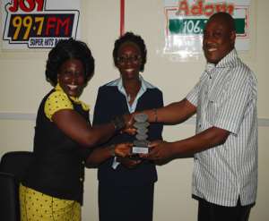 Akumaa Mama Zimbi(left) presenting her award to Mrs Jane Gyekye,(middle) Head of HR and Corporate Resource and Mr Klaus Vonbackustein General Manager Asempa and Adom FM