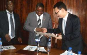 Mr Pan-Kyu Park, leader of the Korean delegation (right), presenting the project document to Nii Nortey Dua (middle). Looking on is the Chief Director of Ghana's Environment Ministry, Alhaji Ziblim Yakubu,