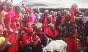 Nene Otibo IV, Mankralo and Acting Paramount Chief of Osudoku Traditional Area holding a bottle of Shnapp as he performs the initiation rites to enstool Nene Animle VI, (left)