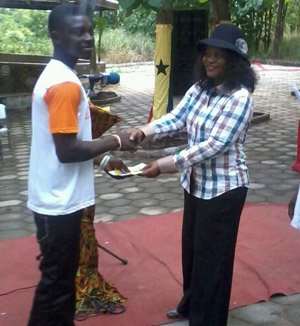 Regional Minister Helen Adwoa Ntoso presenting a prize to one of the bikers