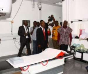 Mr Alban Bagbin in smock being taken round some of the facilities at the Sweden Ghana Medical Centre.