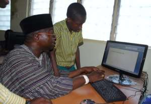 Tobgi Yakah practicing on a computer with a pupil