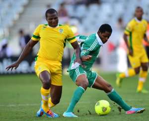 Dumte Pyagbara of Nigeria shields ball from Oscar Machapa of Zimbabwe during the 2014 CAF African Nations Championships 3rd/4th playoff between Zimbabwe and Nigeria at Cape Town Stadium, Cape Town on 1 February 2014