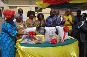 Mrs. Comfort Aniagyei Left being helped by other dignitaries at the ceremony to launch the Northern Star parboiled rice.