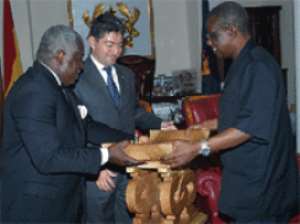 President Mills being assisted by Mr Ken Kanda, Director of State Protocol, to present a stool to the outgoing Italian Ambassador, Mr Luca Fratini when he bid farewell to the President at the Castle, Osu.