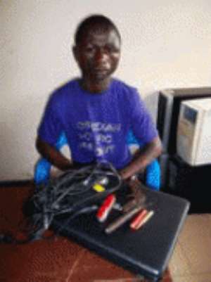 Asamoah displaying the stolen laptop and pistol.after his arrest