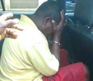 SHAME! Agbofa Yao Hateka hides his face from the cameras