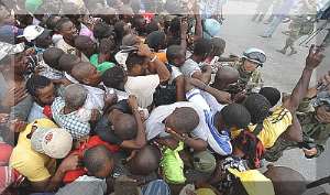 Haitians tear-gased as they scramble for food. Haitians: reduced to animals? Photo courtesy