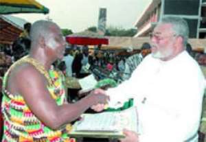Pemanpam Yaw Kagbrese, Yejihene and Vice-President of the Brong Ahafo Regional House of Chiefs, presenting a plaque to former President Rawlings.