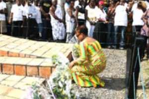 Mrs Okaikoi(squatting), Minister for Tourism, laying a wreath at Assin Manso as a remembrance during this years Emancipation Day.