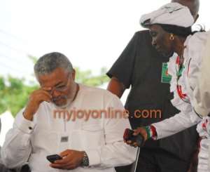 Jerry Rawlings fidgeting with his phone whiles Mrs Rawlings attempts to get his attention