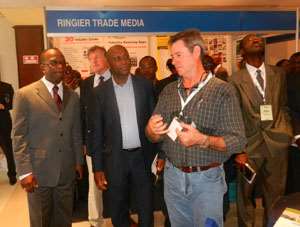Mike Hammah listening to Tony Alllen, an exhibitor as he takes the guest through the operations of Uni-span, a framework and Scaffolding Company at the West Africa Mining and Power Exhibition and Conference in Accra