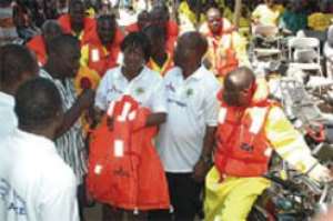 Mr Oscar Provencal (in smock) handing over the items to Mrs Attivor.