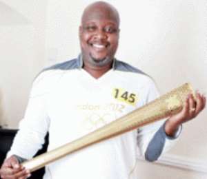 Kwami Sefa Kayi with a replica of the Olympic torch