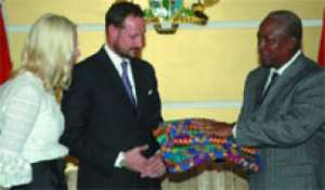 Vice-President John Mahama presenting a piece of Kente to Crown Prince Haakon, accompanied by Princess Mette-Mariti, after their meeting at the Flag Staff House in Accra.