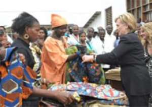US Secretary of State Hillary Rodham Clinton, (right), purchases a shirt, at the Heal Africa clinic in Goma, DR Congo.