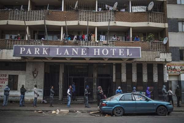 South Africans practise social distancing while they queue outside a supermarket in Hillbrow, Johannesburg during the country's lockdown. - Source: Photo by Marco Longari/AFP via Getty Images