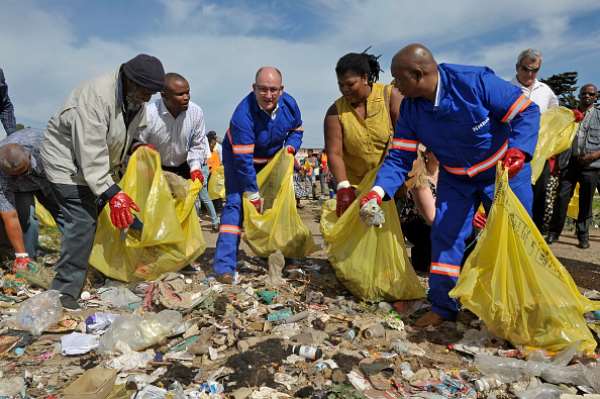 Former Nelson Mandela Bay Mayor Athol Trollip, from the DA, third from left, and his deputy Mongameli Bobani, from the UDM, extreme right, help clean up a street in 2017. - Source: by Werner Hills/Foto24/Gallo Images/Getty Images