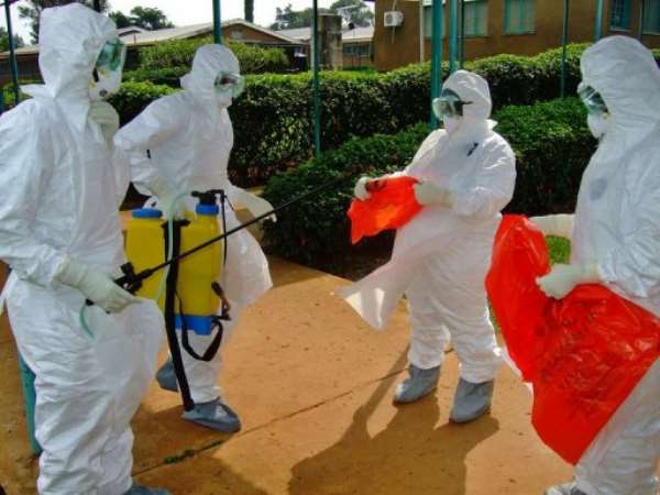 Officials from the World Health Organization wear protective gear as they prepare to enter Kagadi Hospital. By Isaac Kasamani (AFP/File)