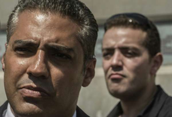Al-Jazeera journalists, Canadian Mohamed Fahmy (left) and Egyptian Baher Mohamed, wait outside Cairo's Torah prison where their trial was due to take place on July 30, 2015. By Khaled Desouki (AFP/File)