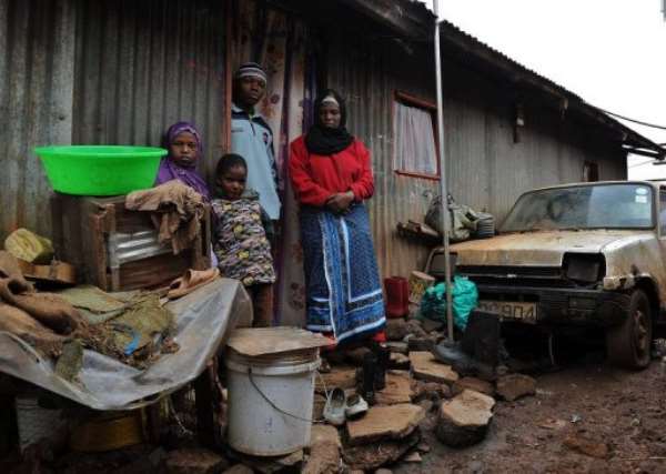 Latifah Naiman (R) stands with her children in front of her house in the Nairobi slum of Kangemi on August 3, 2013. By Tony Karumba (AFP)