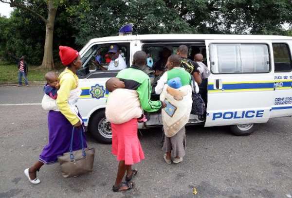 Members of the South African Police Service escort foreign nationals after a xenophobic attack in Durban on April 8, 2015. By Rajesh Jantilal (AFP/File)