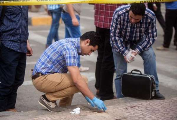 Egyptian forensics inspect the site following a bomb attack targeting a security checkpoint in central Cairo on April 15, 2014. By Mahmoud Khaled (AFP)