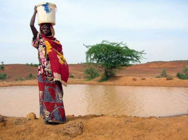A woman continues to get water from a pool infected with cholera in Niger in 2005. By Natasha Burley (AFP/File)