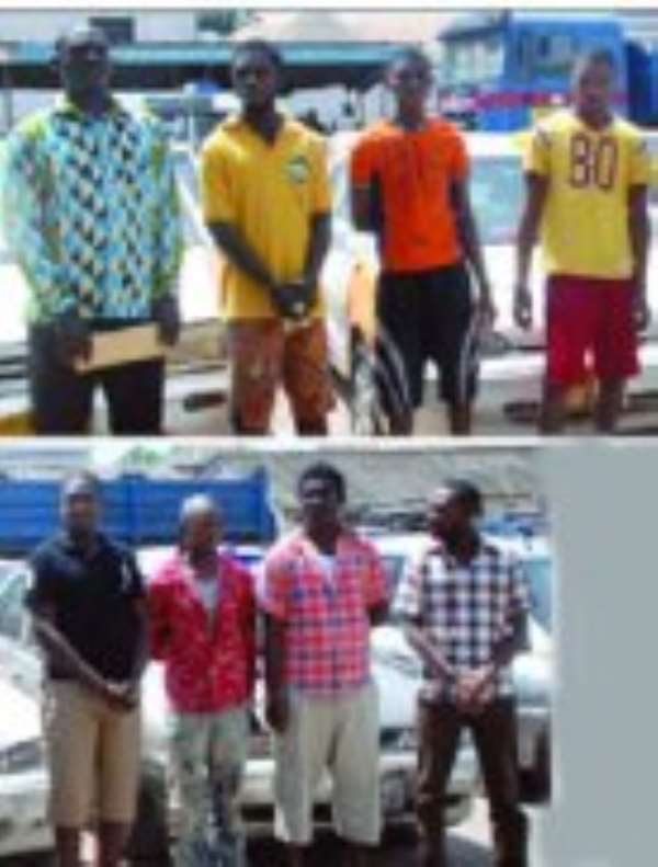 Some of the suspects in front of the stolen vehicles.