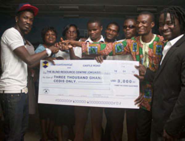 Tinny presenting cheque to Mr Koufie, head of the resource centre (2nd right).