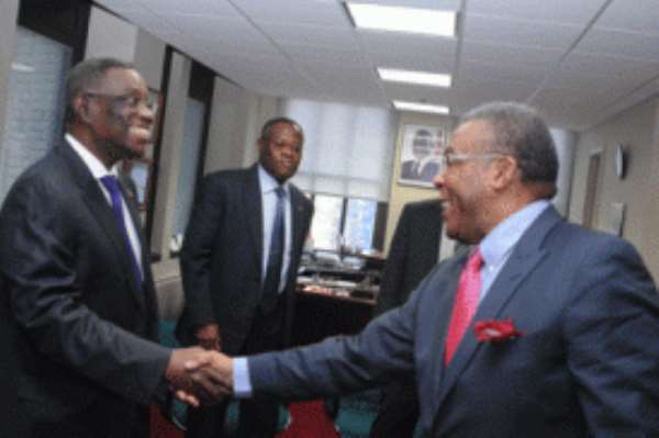 President Mills in a handshake with chairman of board of directors of Kosmos Energy, John Kemp, in New York