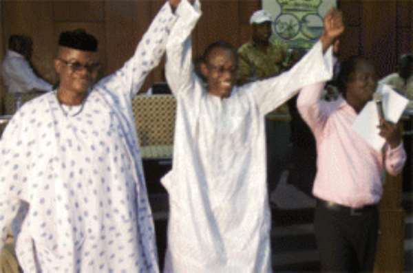 Mr Richard Asensu (R) with Mr Edumadze Acquah (L) raise Mr Sam's hands to declare him KEEA Municipal Chief Executive.