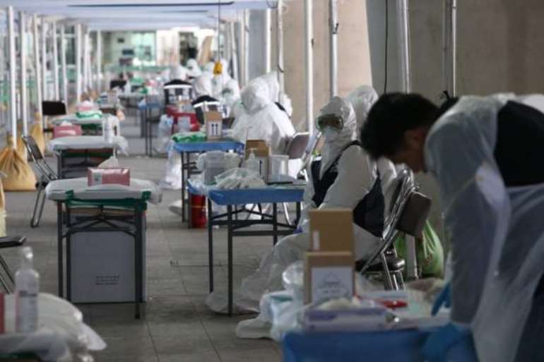 Medical workers test foreign passengers as they arrive at Incheon airport in South Korea