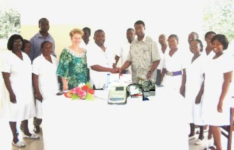 Mr. Obed Komla Adore, a registered nurse and treasurer to GCNAO being thanked with a handshake by Dr. Dogbatse, the medical officer of the Patang Physical OPD. Standing to the immediate right of Dr. Dogbatse is Dr. Anna Puklo-Dzadey- medical director of the hospital. Others in the picture include Mrs. Margaret Patterson (in purple sash) the Superintendent of the Pantang Nursing Training College and other senior staff of the hospital.