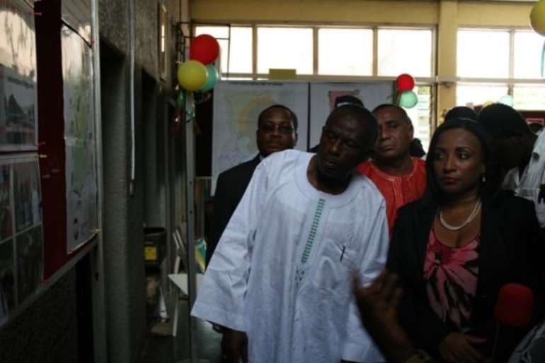 Mr Colins Dauda, (left) Minister of Lands and Natural Resources looking at exhibition pictures. With him is Mrs Zita Okakoi, (right) Minister of Information.