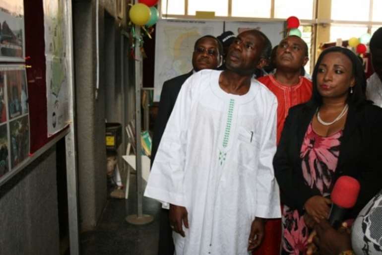 Mr Colins Dauda, (left) Minister of Lands and Natural Resources looking at exhibition pictures. With him is Mrs Zita Okakoi, (right) Minister of Information.