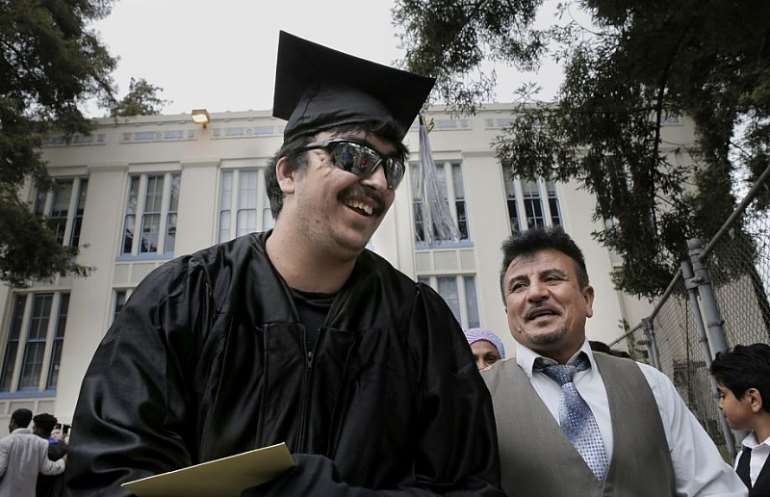 Saleh Khalaf and father Raheem smile after Wednesday's graduation ceremonies in Oakland. Photo: Michael Macor / San Francisco Chronicle