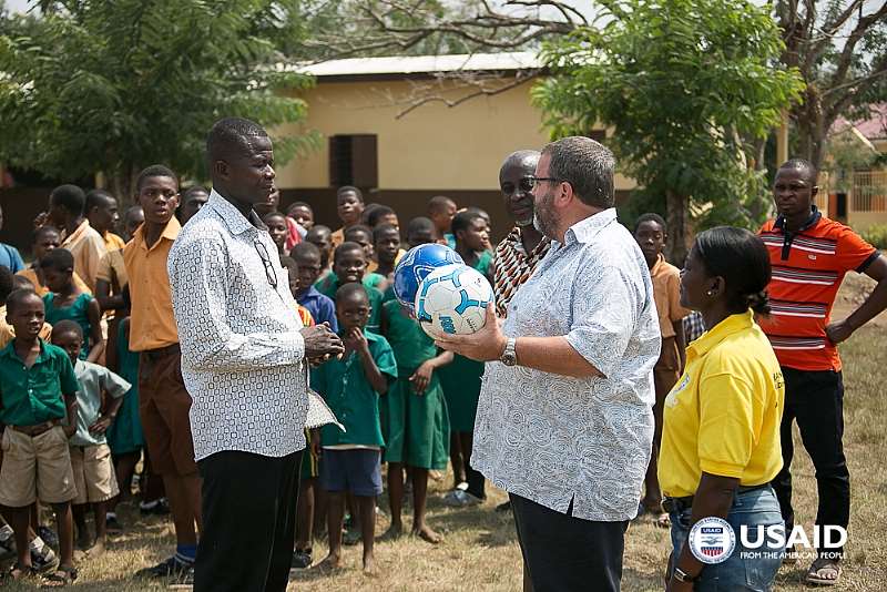 USAID Volta School Visit: USAID/Ghana Mission Director Andy Karas presents footballs to students and teachers in Fodzoku, Ghana, where USAID supported the construction of a new kindergarten. Photo Credit: Yooku Ata-Bedu, USAID/Ghana