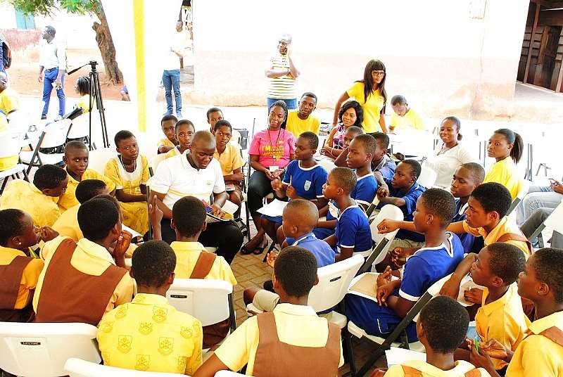Mr Joseph Dogbe Reading With Some Of The Pupils Of Kwashie Cluster Of School