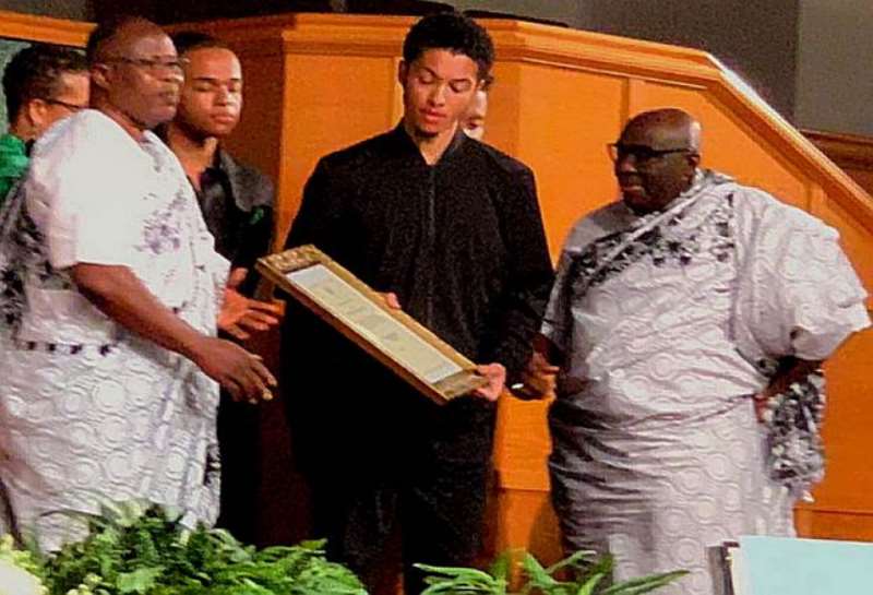 Deputy Minister of Foreign Affairs, supported by HE Papa Owusu Ankomah, presenting the posthumous award to the son of Dr Teye-Botchway.