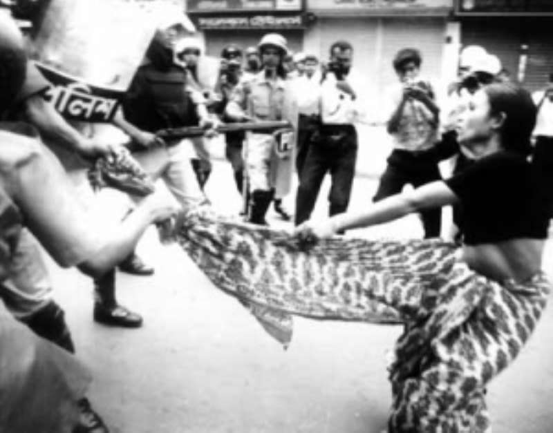 A woman being harassed by male police officers on the street.