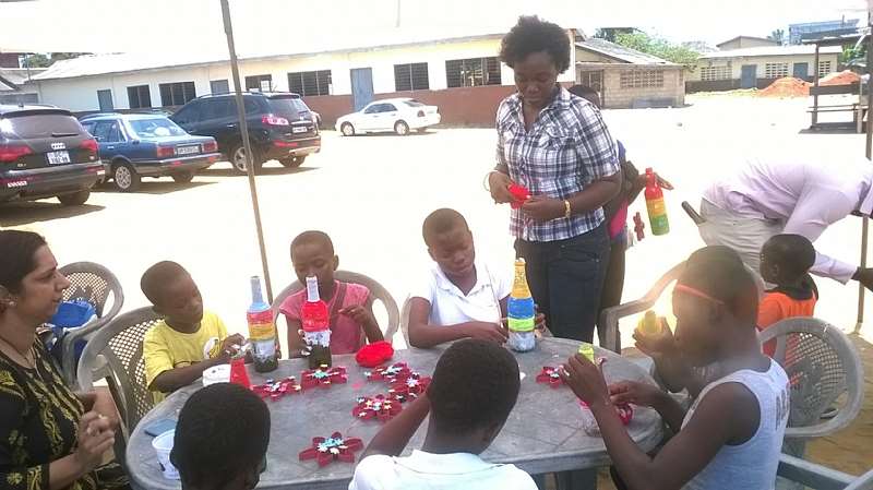 children turning bottles into vase