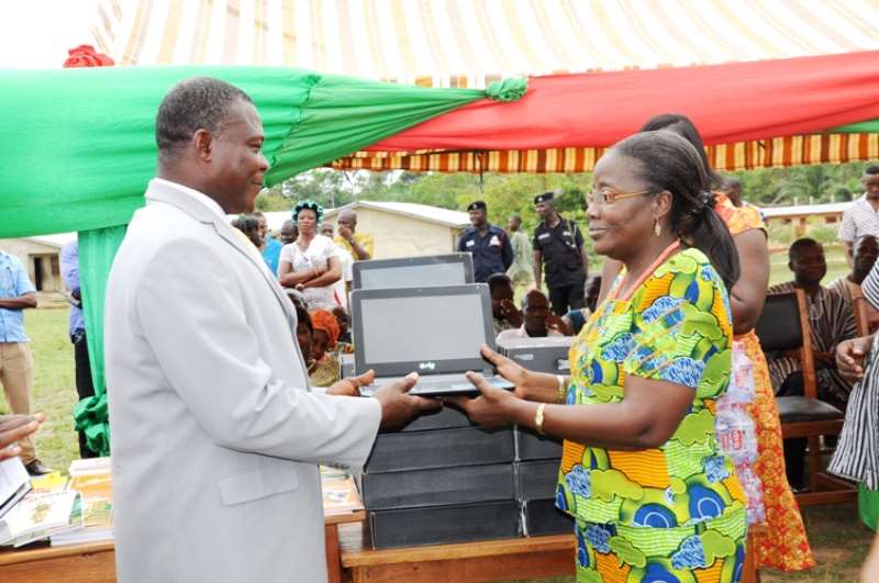 MRS. MATILDA AMISSAH-ARTHUR PRESENTS 10 COMPUTERS AND BOOKS TO THE HEADTEACHER OF THE NTRONANG BASIC SCHOOL MR. EMMANUEL AGBEKO (1)